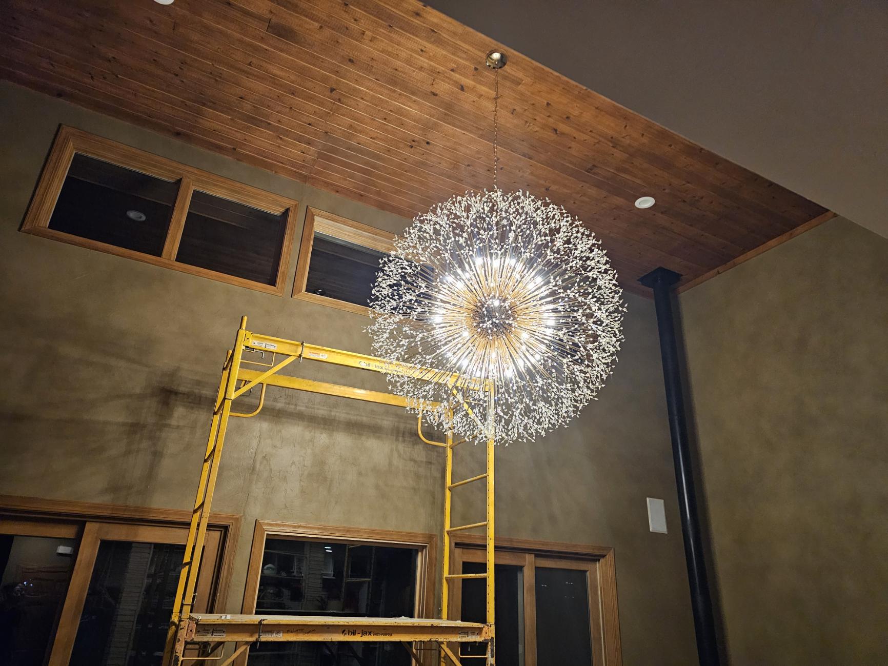 Large crystal chandelier under wood plank ceiling